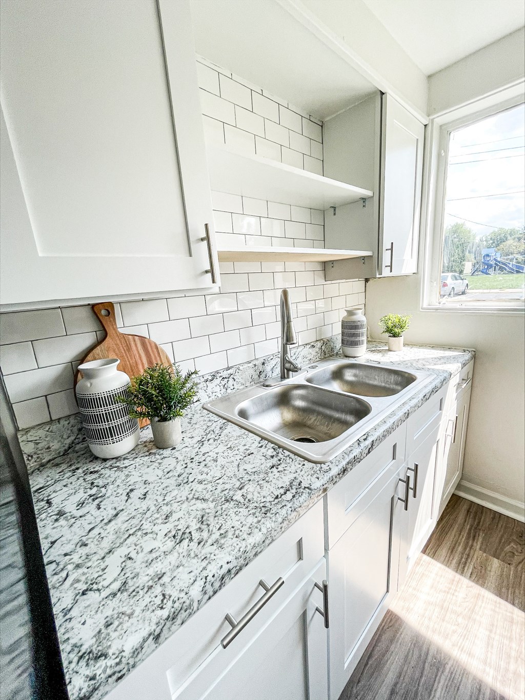 a kitchen with white cabinets and a counter top with a sink at Townhomes at 28th, Indiana, 47201