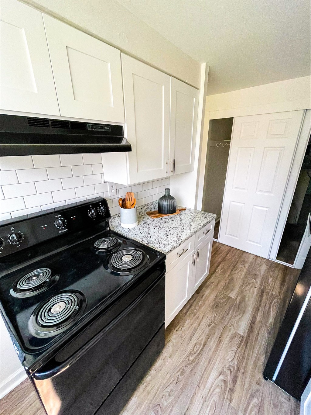 a kitchen with white cabinets and a black stove top oven at Townhomes at 28th, Columbus, IN, 47201