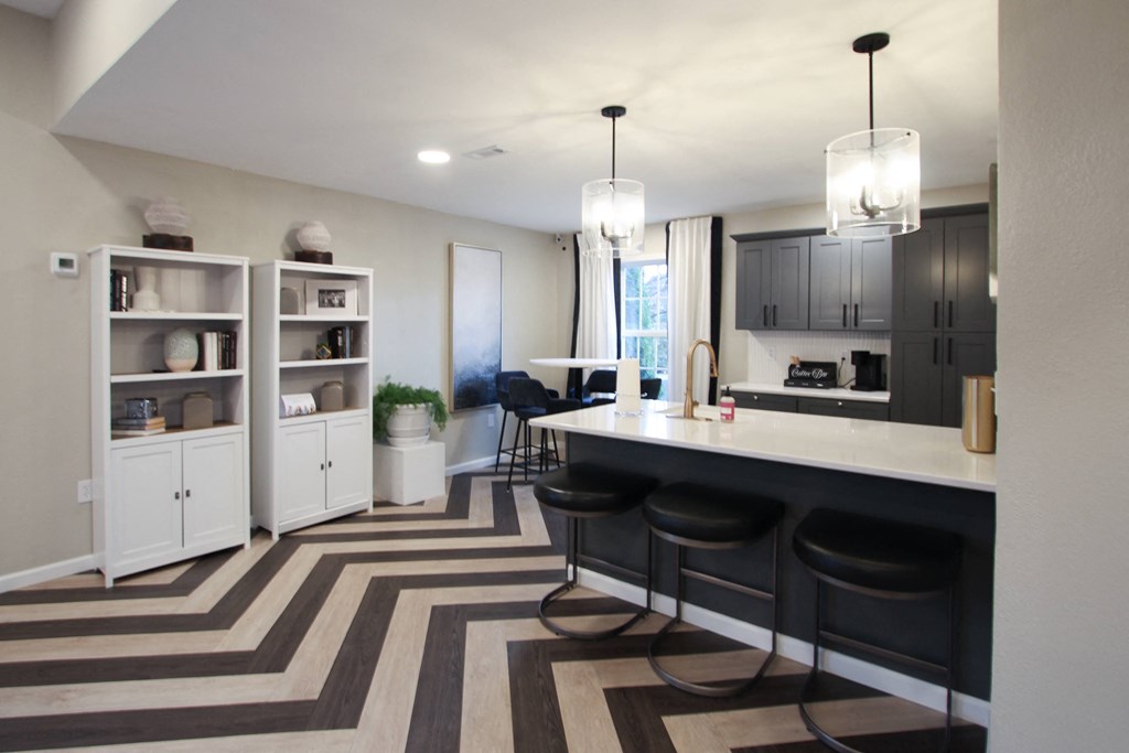 a kitchen and dining room with black cabinets and a striped rug
