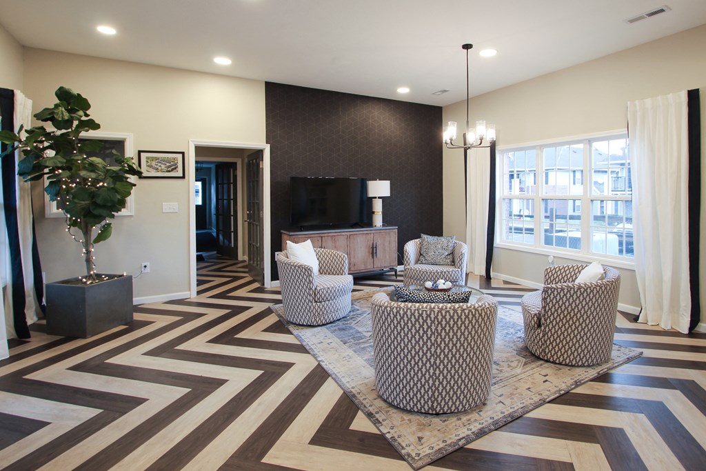 a living room with chairs and a table and a television