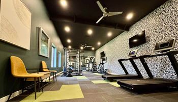 A gym with a treadmill, weights, and exercise equipment at Townhomes at 28th, Columbus, IN, 47201