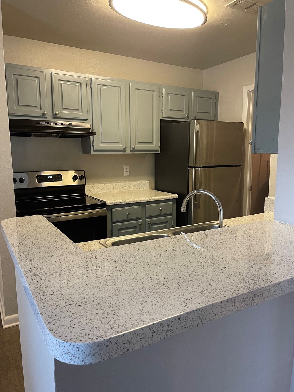 a kitchen with granite counter tops and stainless steel appliances at Aqua Bay Apartments in Naples, FL 34116