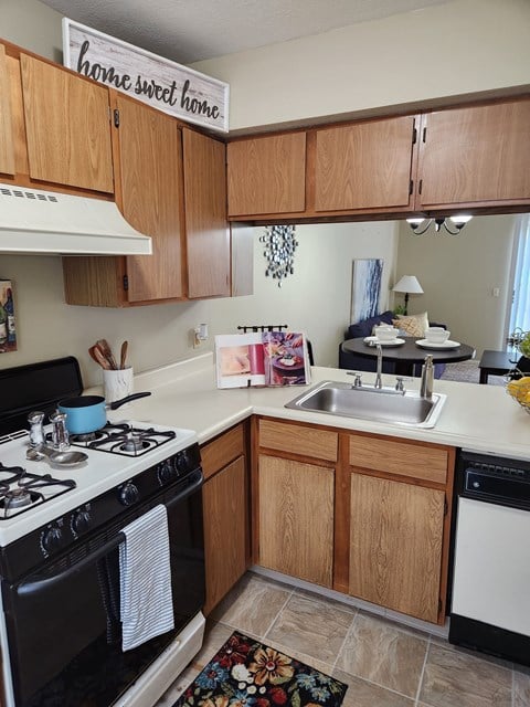 A kitchen with wooden cabinets and a sign that says "home sweet home".