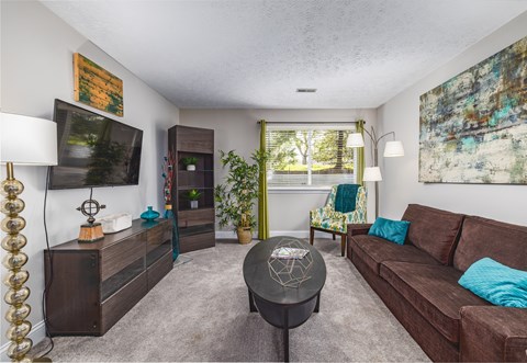 A living room with a brown couch and a black coffee table.