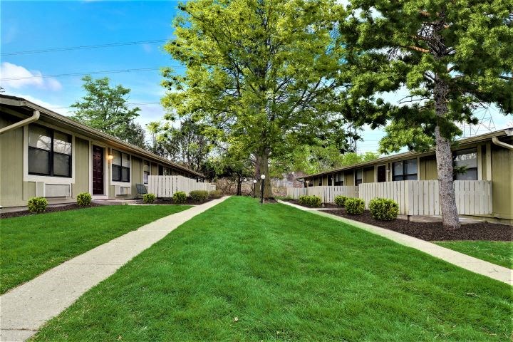 a sidewalk in front of a row of houses