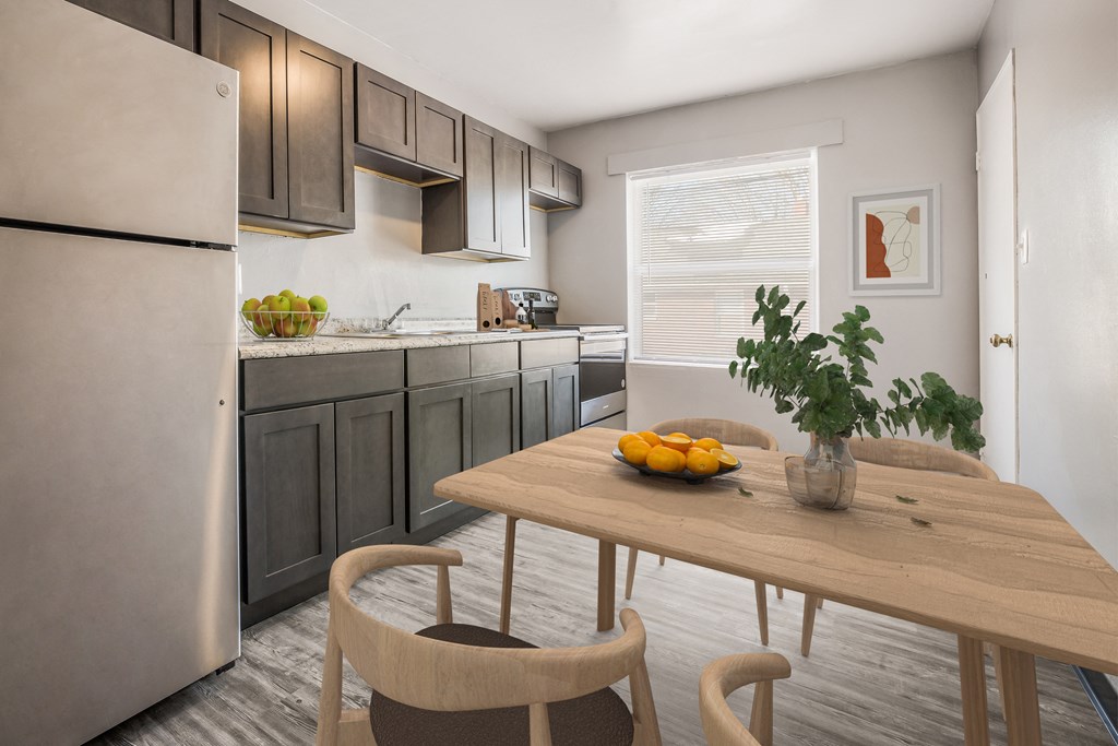 a kitchen with stainless steel appliances and a table with fruit