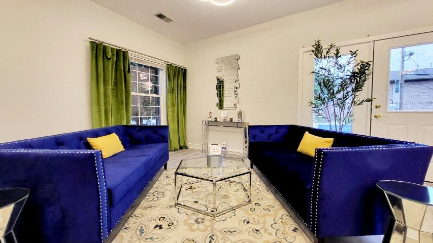 a living room with two blue couches and a glass coffee table