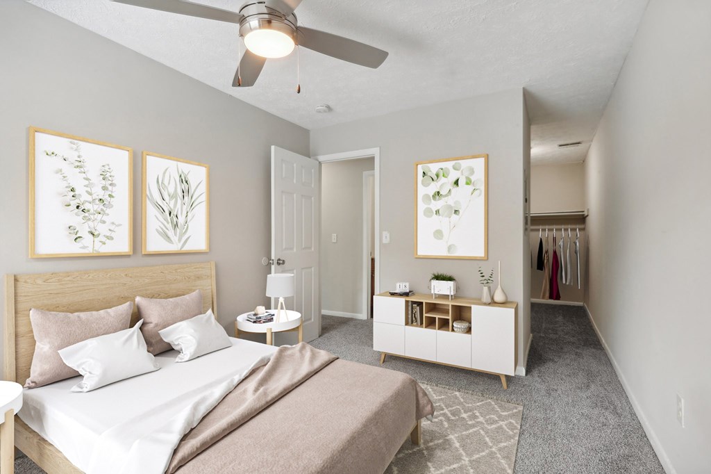 A bedroom with a bed, nightstand, and a ceiling fan.