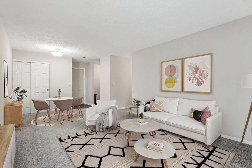 A living room with a white couch, a coffee table, and a rug with a geometric pattern.