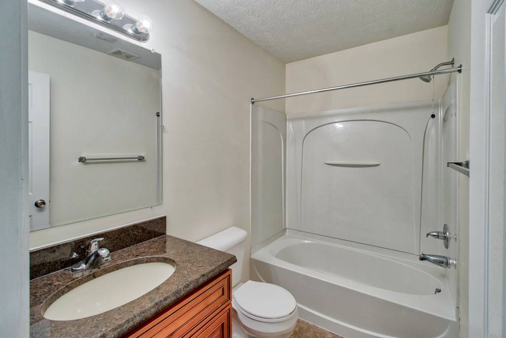 A bathroom with a sink, toilet, and bathtub.