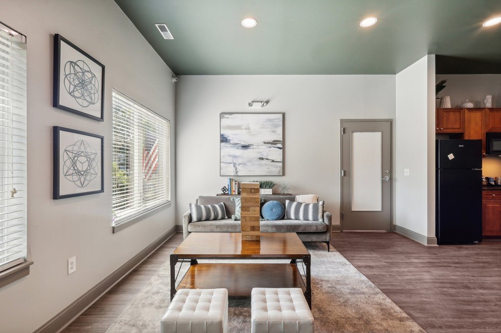 A modern living room with a wooden coffee table and a painting on the wall.