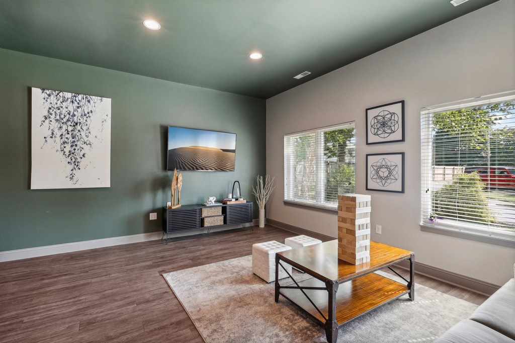 A living room with a wooden floor and a large window.