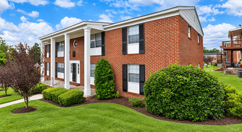 A red brick house with white trim and a porch.