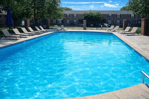 A large blue swimming pool surrounded by lounge chairs.