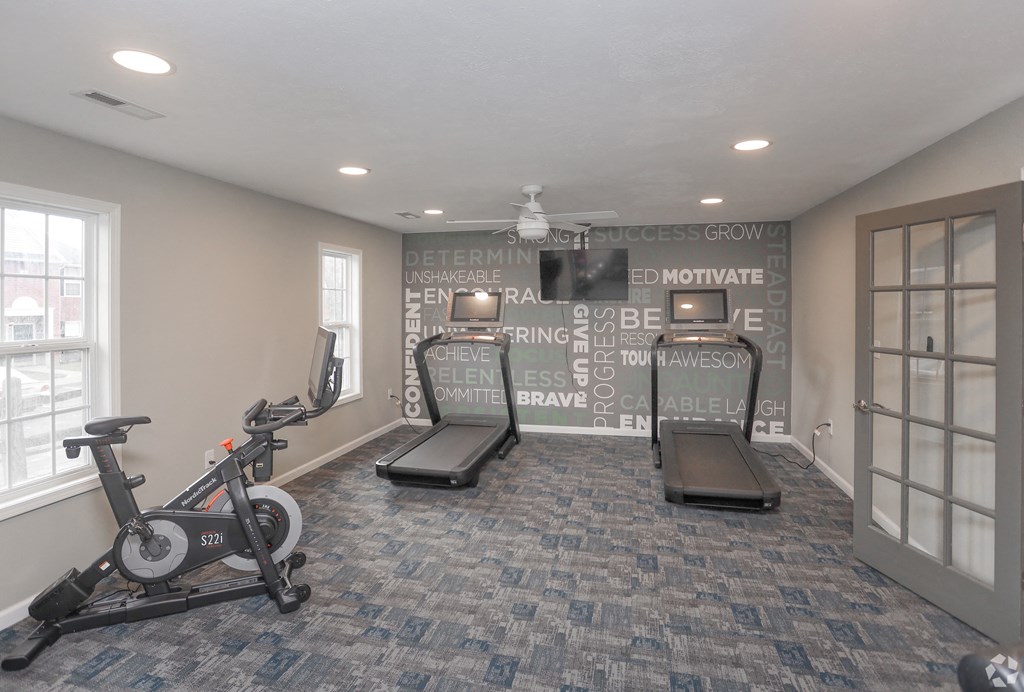a home gym with exercise equipment and a wall with writing on it