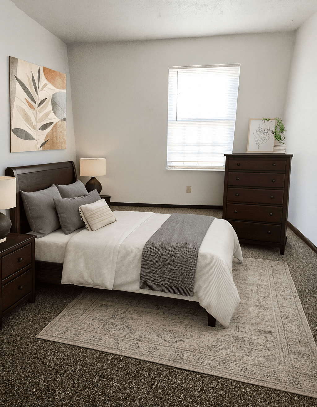 A bedroom with a bed, nightstand, and dresser.