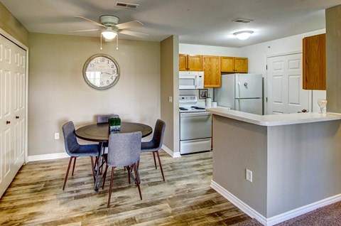 A kitchen with a table and chairs and a clock on the wall.