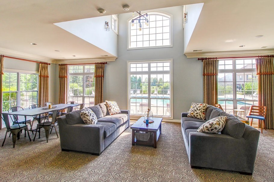 A living room with two grey couches and a table in the middle.