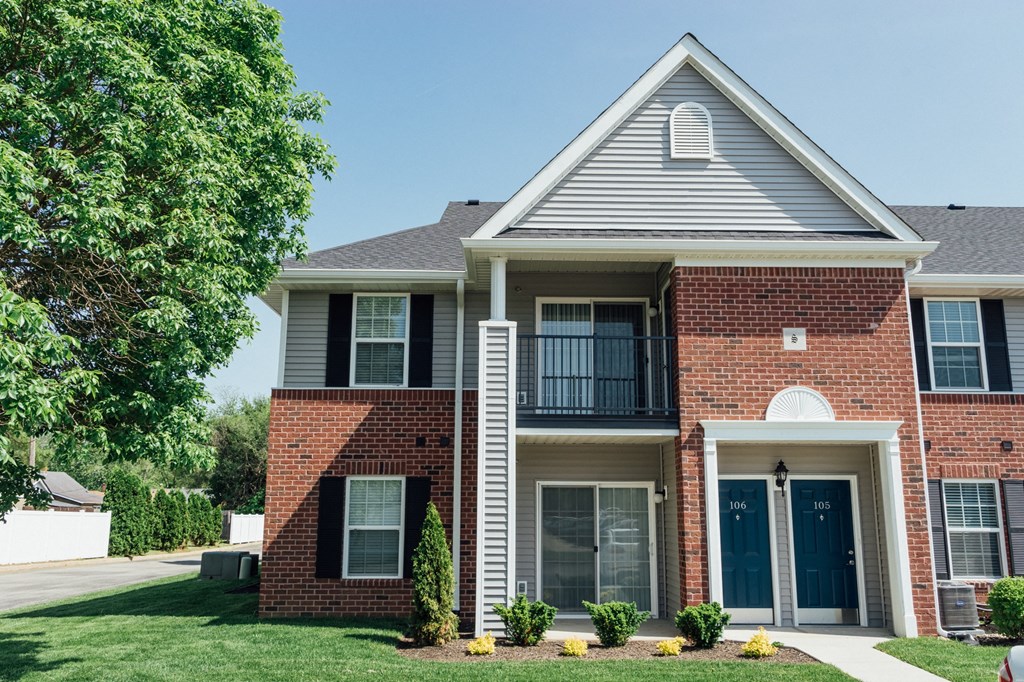 a brick house with a tree in front of it
