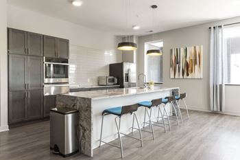 A modern kitchen with a marble island and stainless steel appliances.