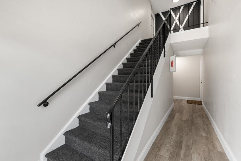 a view of the stairs from the bottom of the staircase in a home with white walls and