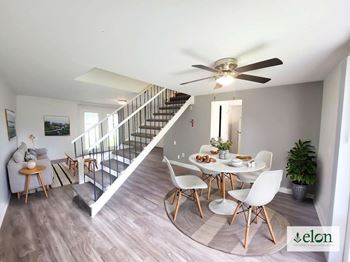 A dining room with a table set for four and a staircase at Townhomes at 28th, Indiana, 47201
