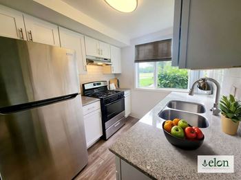 A modern kitchen with a stainless steel refrigerator and a bowl of fruit on the counter at Townhomes at 28th, Indiana, 47201