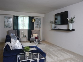 Carpeted living room at Deer Park Apartments - Photo Gallery 3
