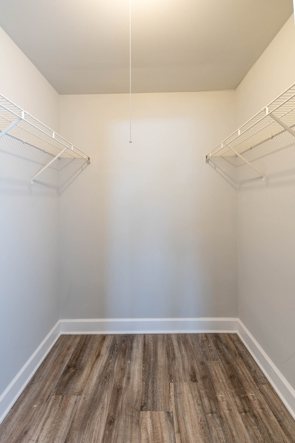 A closet with white walls and wood floors at McDonogh Village Apartments & Townhomes, Randallstown, MD
