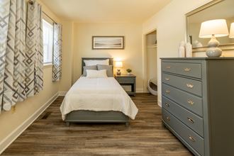 a bedroom with a bed and dresser in a 555 waverly unit - Photo Gallery 4