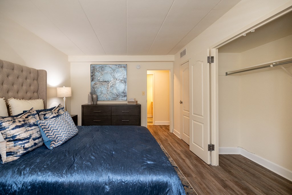 Bedroom with a bed and a dresser and a door to a bathroom at Ivy Hall Apartments*, Towson, MD 21204.