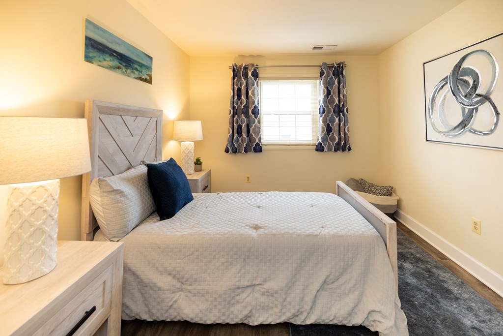 Bedroom with a large bed and a window at Rockdale Gardens Apartments*, Baltimore.