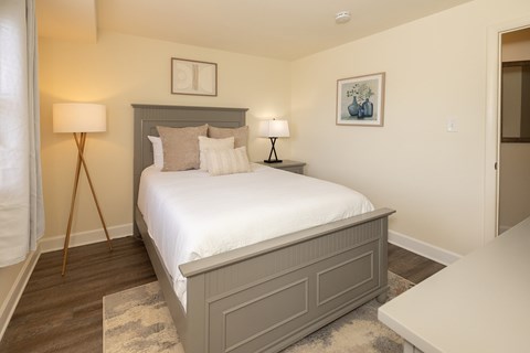 A bedroom with a large bed and two lamps.