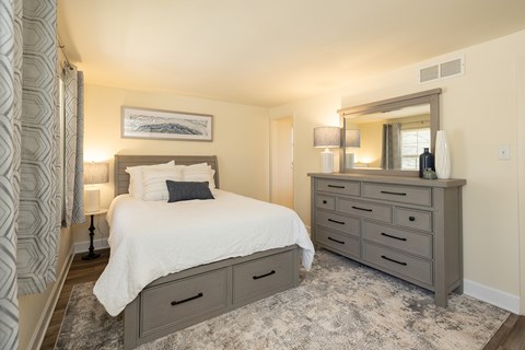 Primary bedroom with bed and dresser with mirror