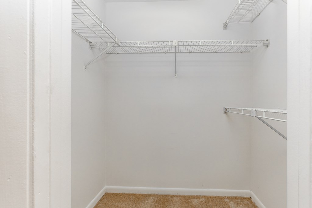 Empty walk-in closet with white walls and shelving at Spring Hill Apartments & Townhomes, Baltimore