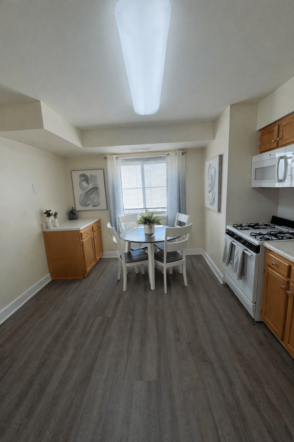 A kitchen with a table and chairs in the middle of the room.