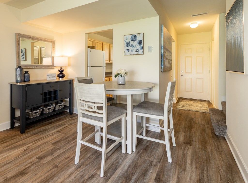 A dining room with a table and chairs.