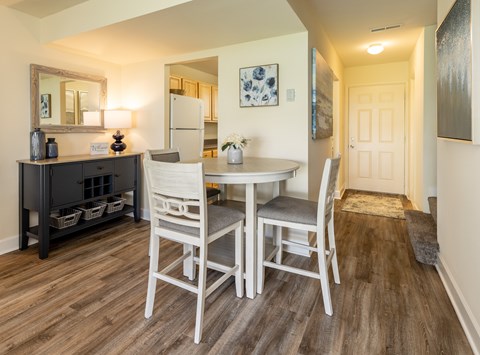 A dining room with a table and chairs.