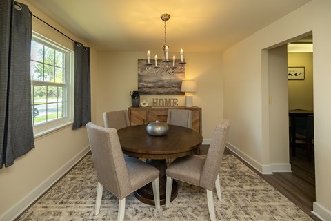 A dining room with a wooden table and chairs at The Brittany Apartments, Maryland