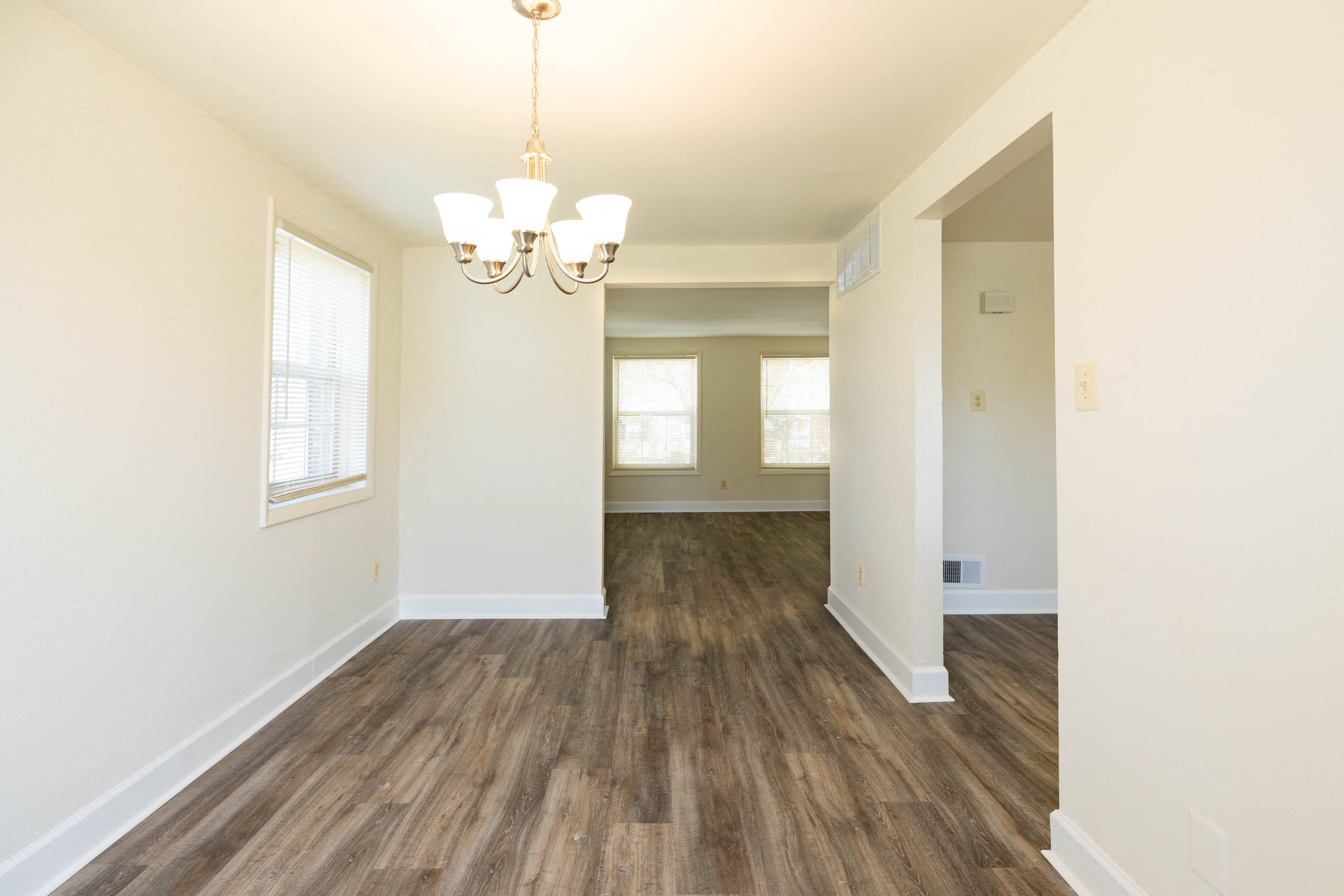 an empty living room with a chandelier
