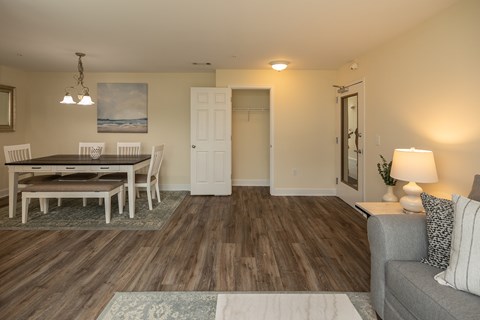 A living room with a grey couch and a wooden floor.