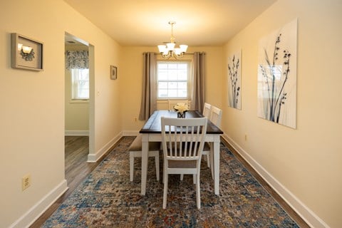 a dining room with a table and chairs and a window