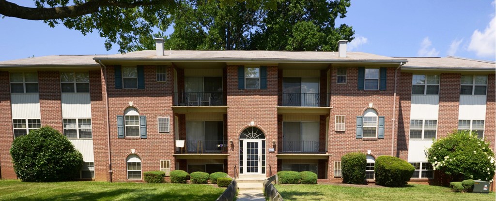 A red brick apartment building with a white door and windows.