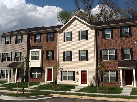 Large apartment building with a red door at The Pointe at Manorgreen Townhomes, Baltimore, 21220