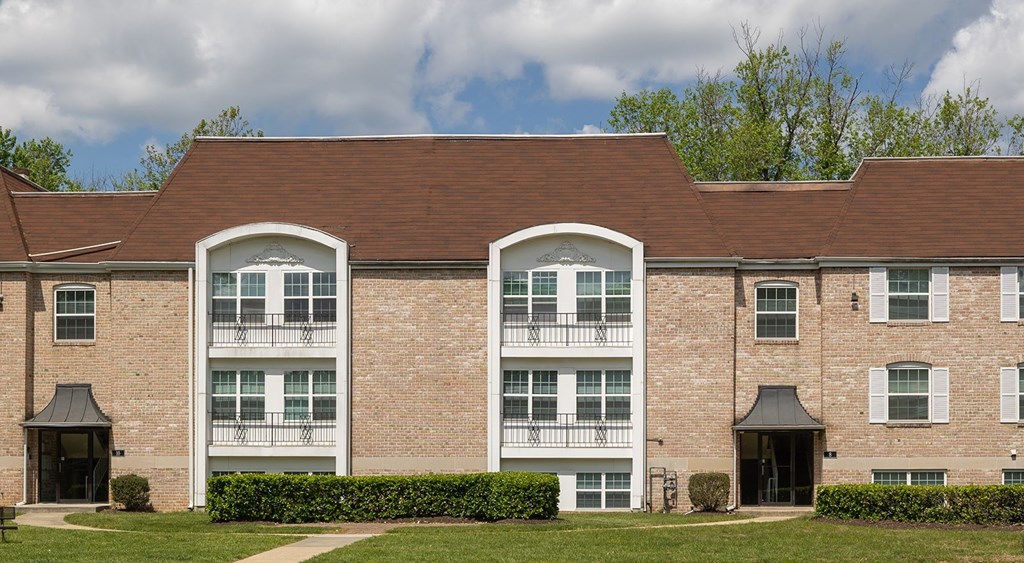 A large brick building with two balconies in the front at The Brittany Apartments, Maryland