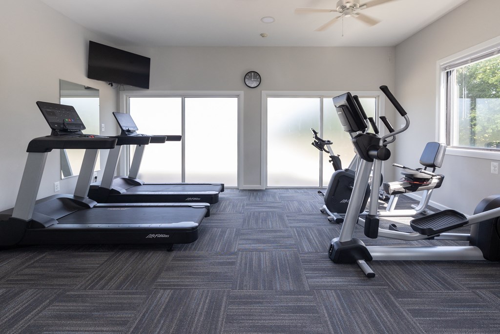 Gym with treadmills and other exercise equipment in a building with windows at Cromwell Valley Apartments, Towson