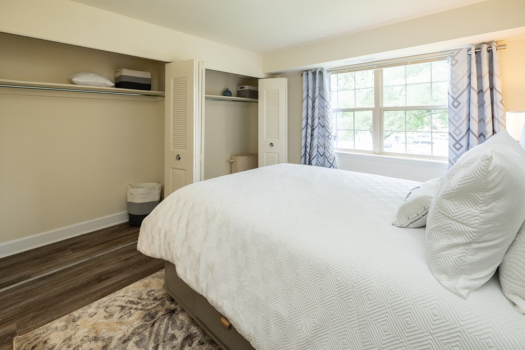 a bedroom with a large white bed and a window