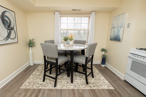 A dining room with a table set for four.