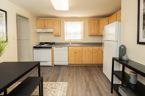 A kitchen with wooden cabinets and a black counter top.
