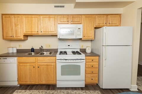 A kitchen with wooden cabinets and white appliances.
